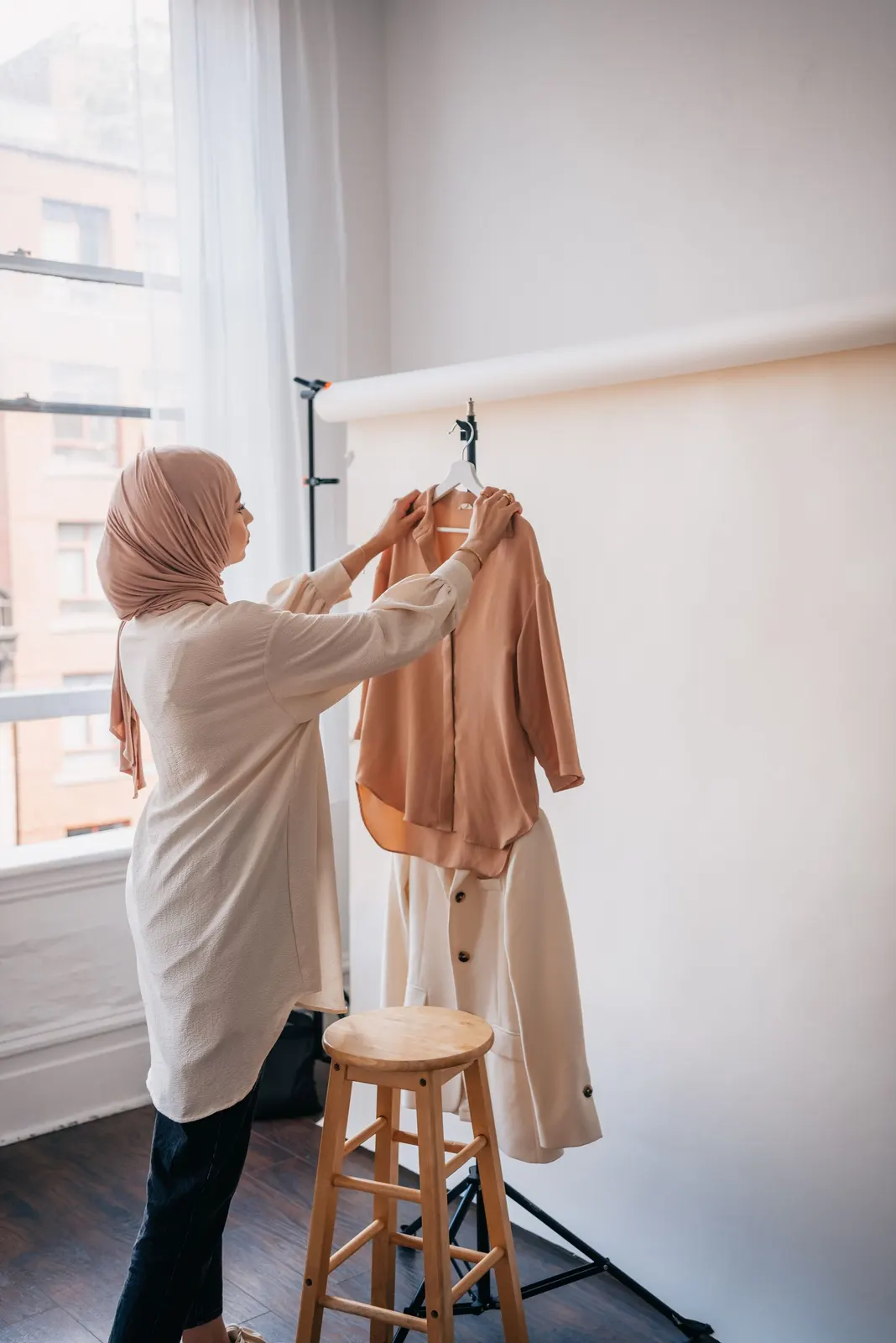 Styling pieces from a garment rail in a light studio